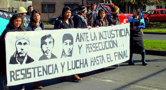 Mapuche protesters hold banner with mages of the three men on hunger strike. ‘In the face of injustice and persecution resist and fight until the end