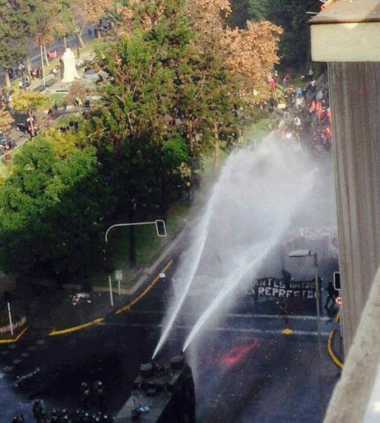 Police using a water cannon on protestors