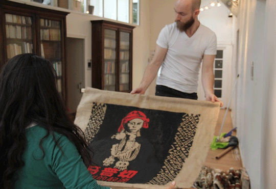 Two people holding a fabric poster